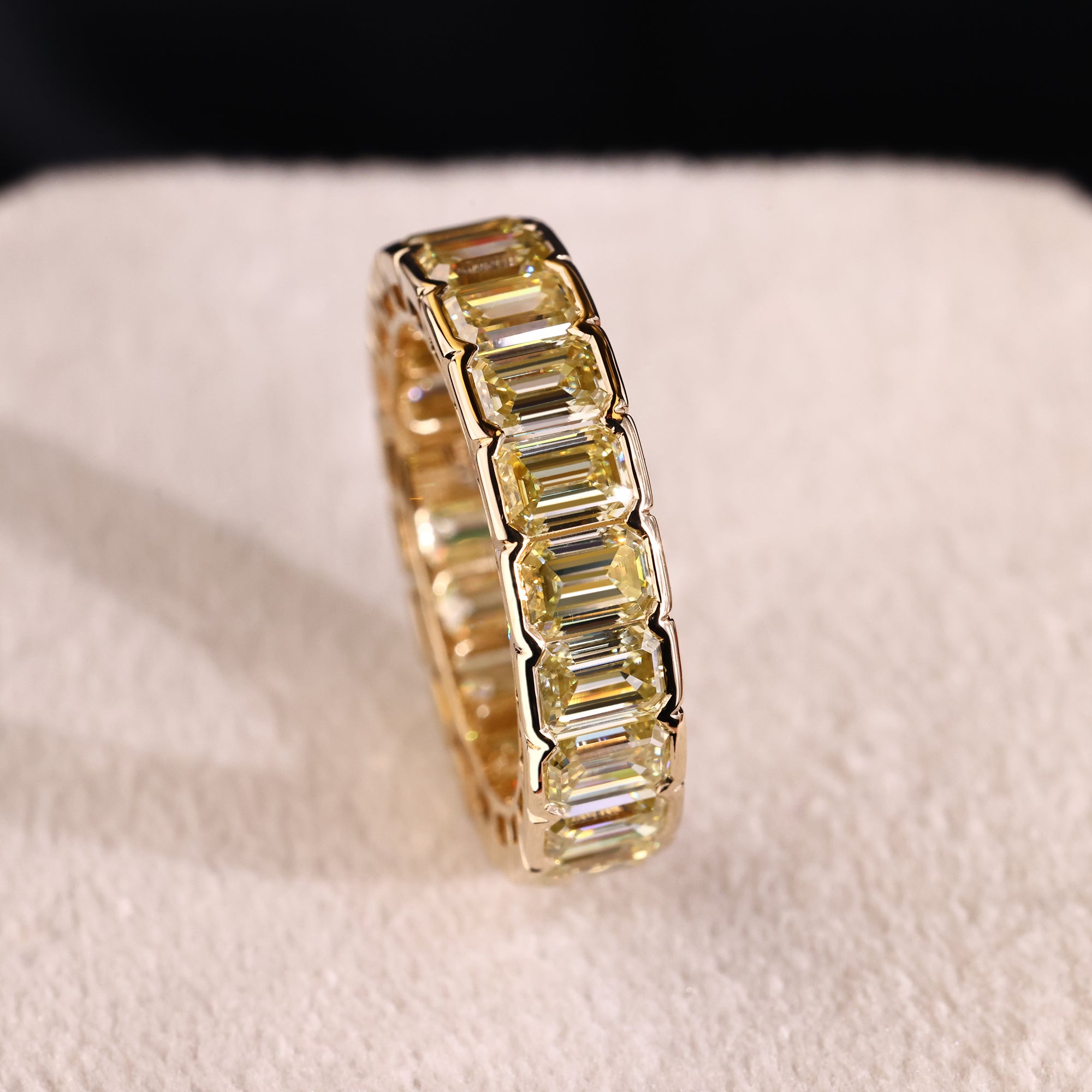 Half bezel setting in emerald cut moissanite ring.