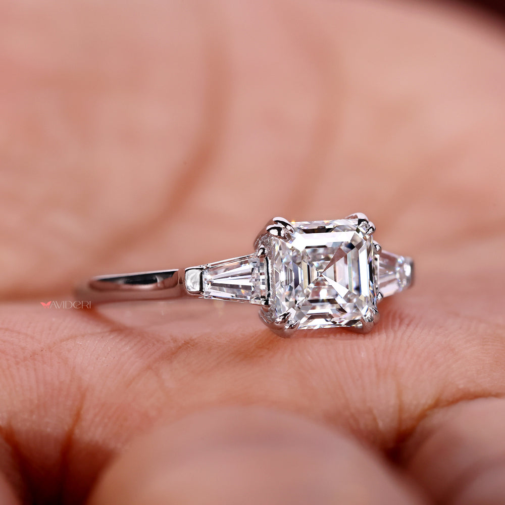 Tapered engagement ring featuring Asscher cut moissanite and double claw for secure and stylish gemstone settings.
