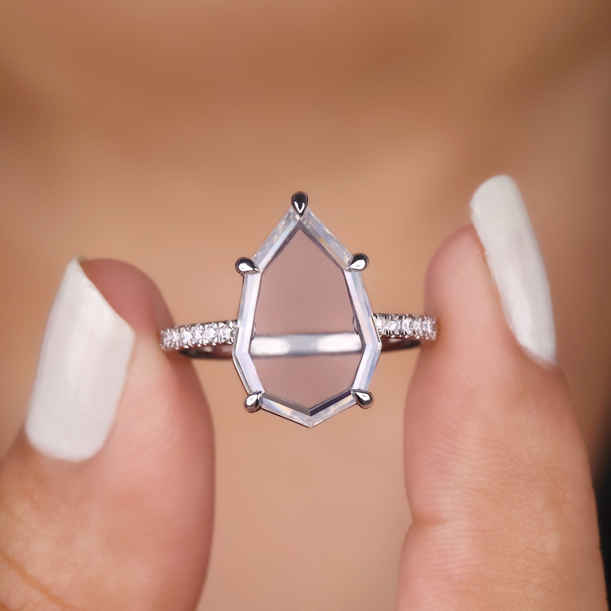Portrait cut engagement ring with a brilliant moissanite center.
