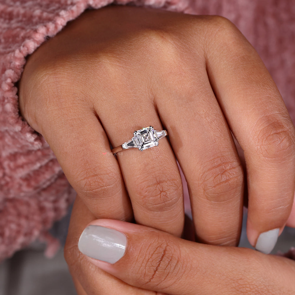 Double prong engagement ring featuring a Three Stone Engagement Ring design with Two tapered baguette side stones.
