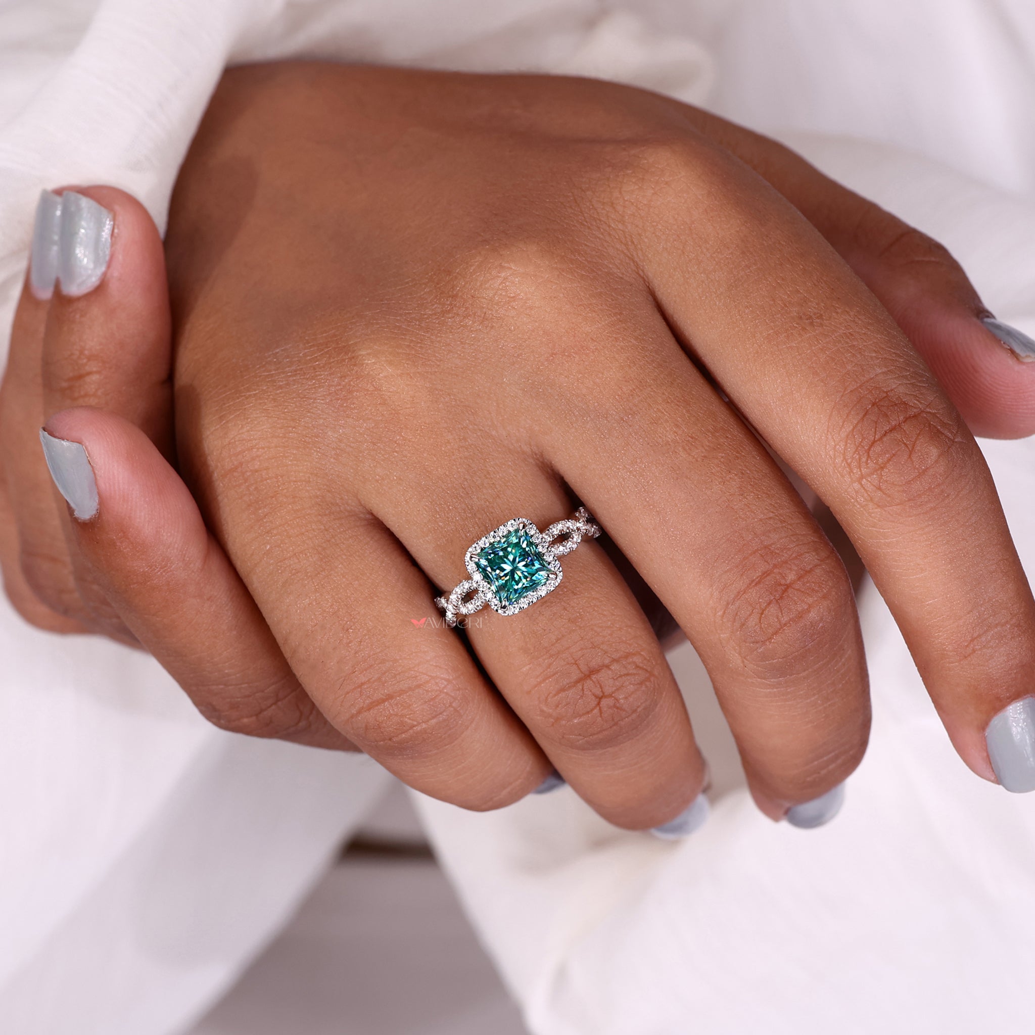 White gold halo set ring with brilliant stones surrounding the center.
