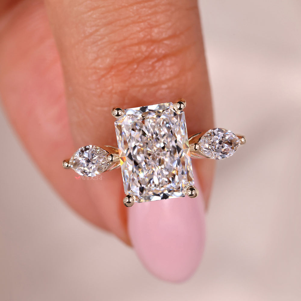 Three stone engagement ring with radiant diamond detailing.
