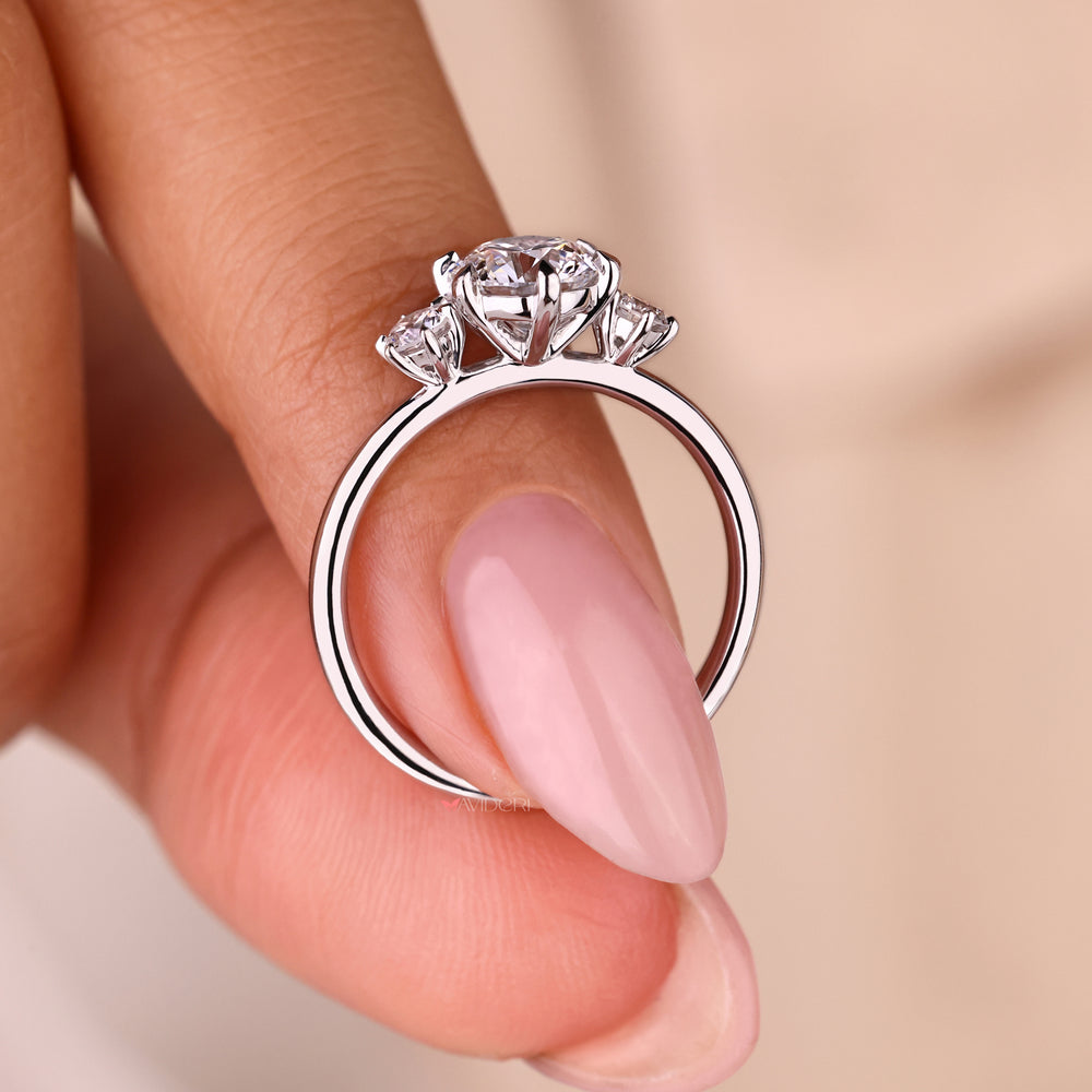 Three stone engagement ring round cut with a flush set diamond band.
