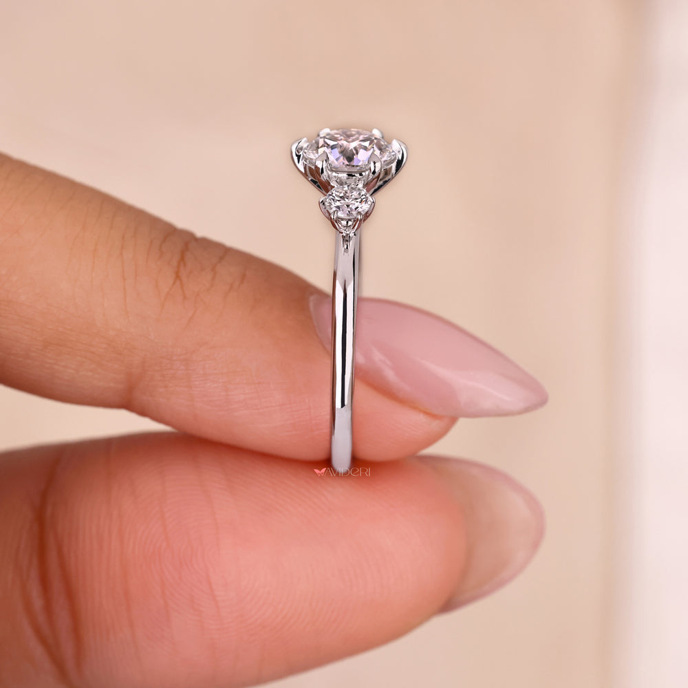 Elegant three stone round diamond ring in high set engagement ring design.
