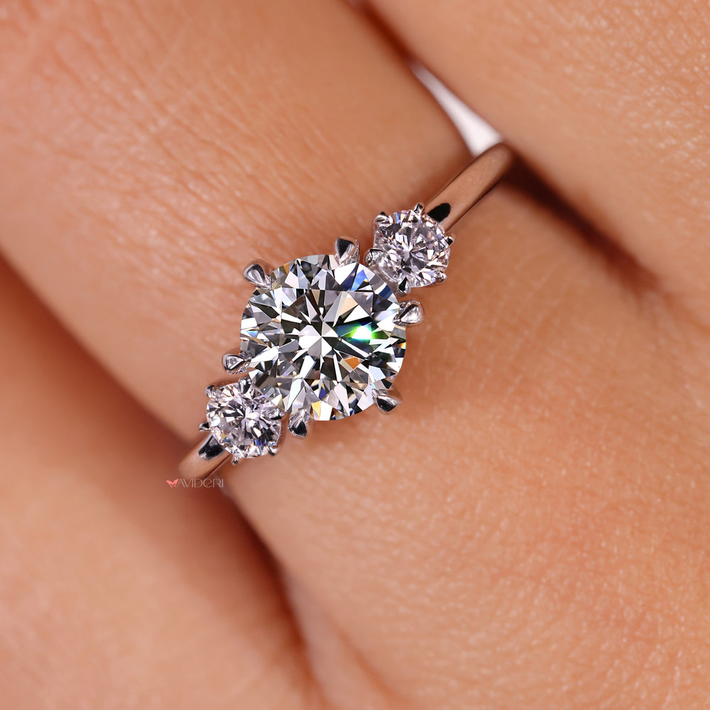 Round cut diamond ring featuring claw prongs and handmade jewelry touches.
