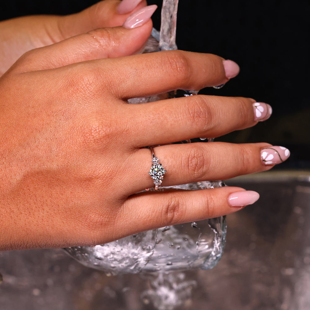 Three stone round engagement ring with side accents in white gold.
