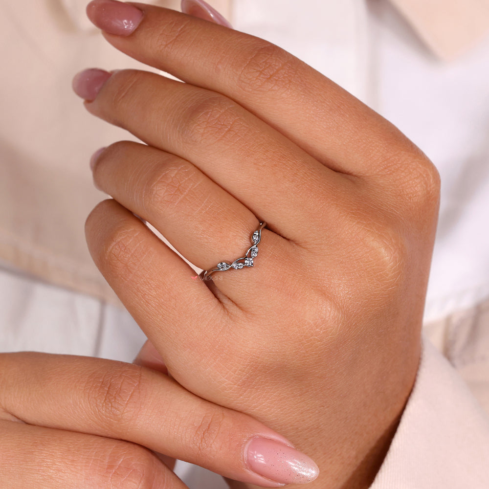 Curved diamond wedding band crafted with a round prong ring design.
