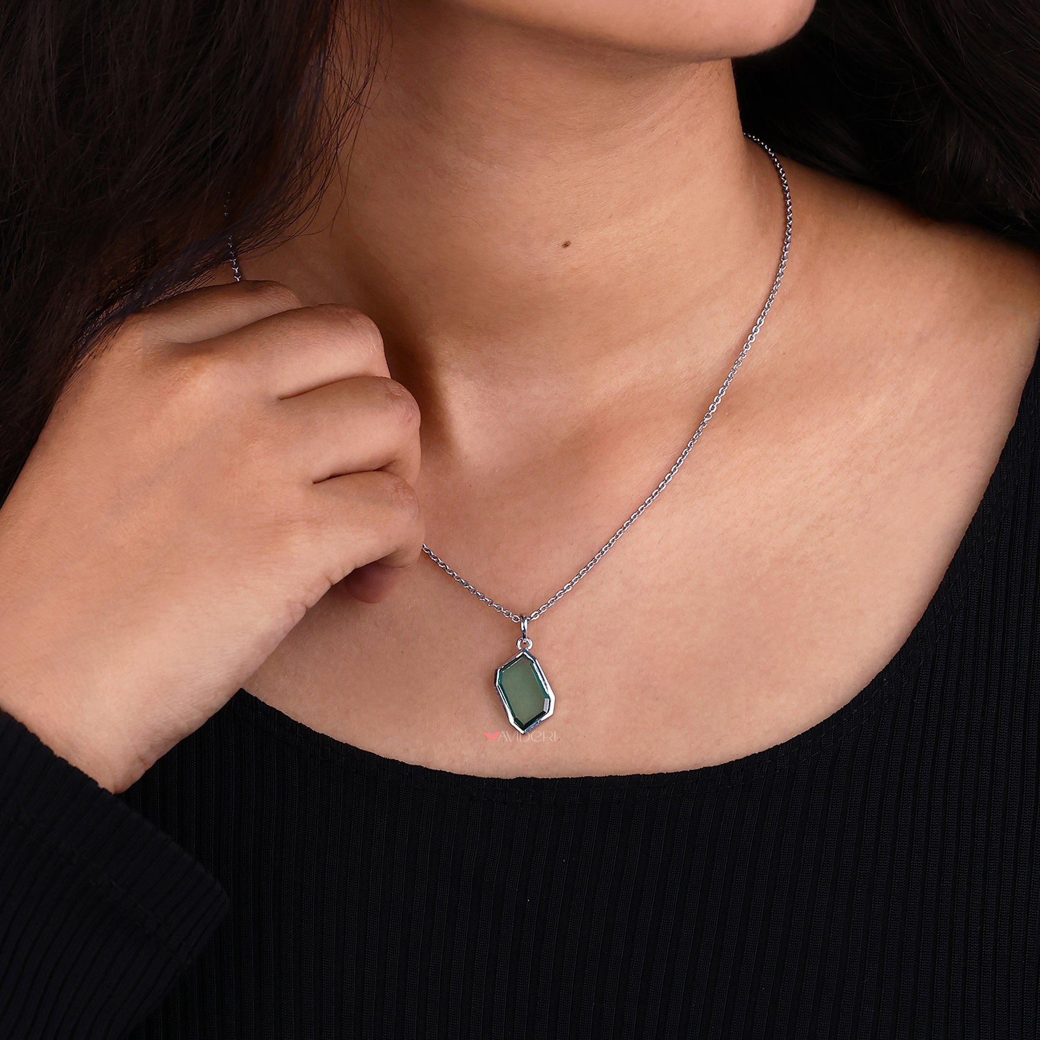 Green stone pendant adds a vibrant touch.
