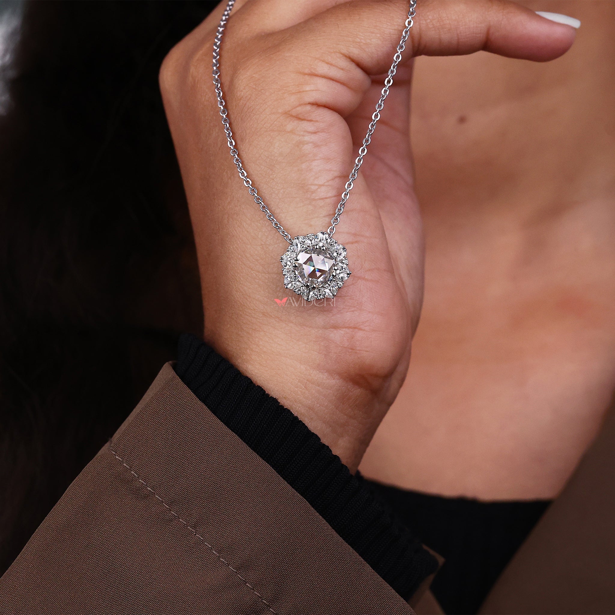 Round and marquise cut halo pendant with a handcrafted finish.