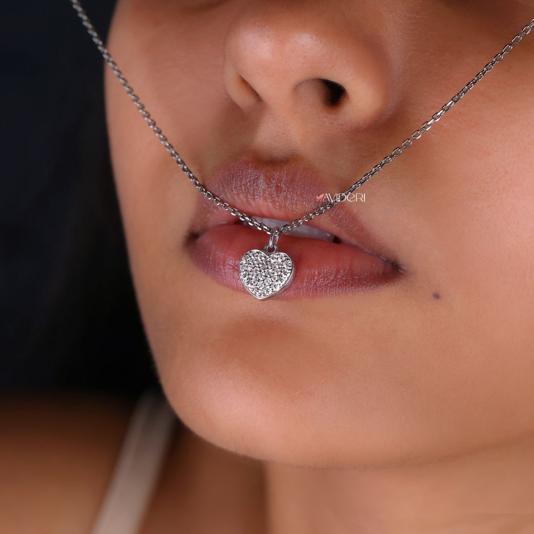 Round cut pendant featuring a heart shape with a moissanite stone.
