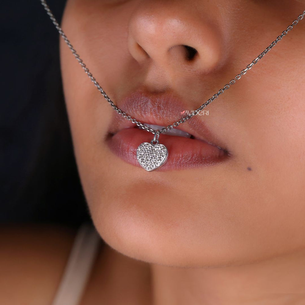 Round cut pendant featuring a heart shape with a moissanite stone.
