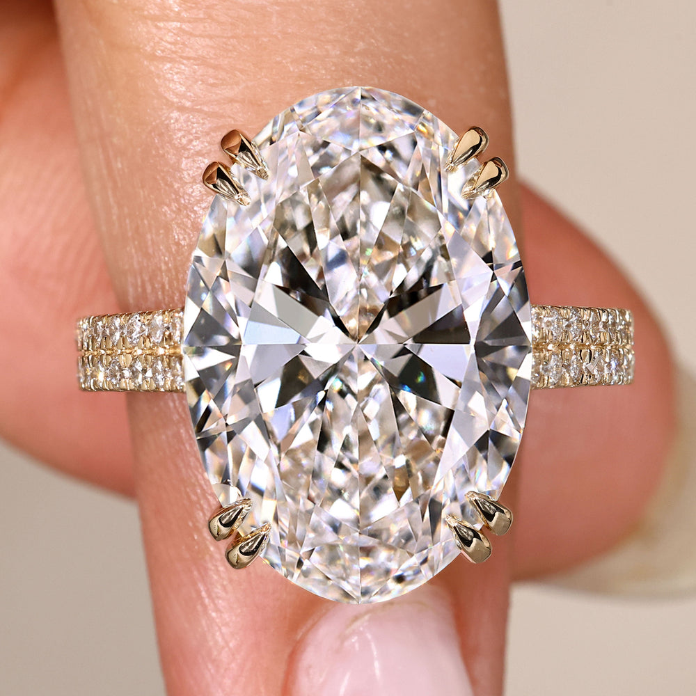 Oval diamond ring with cathedral setting and pave.
