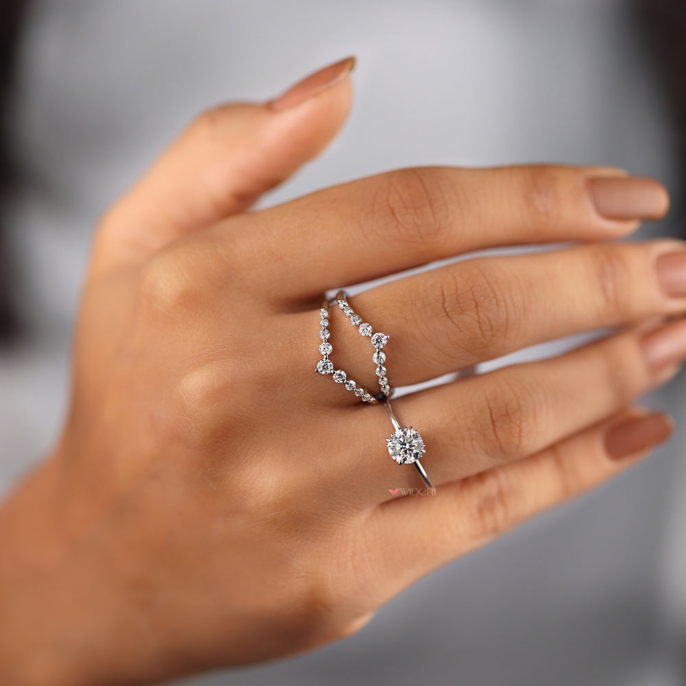 Fishtail prong ring featuring a round cut solitaire.

