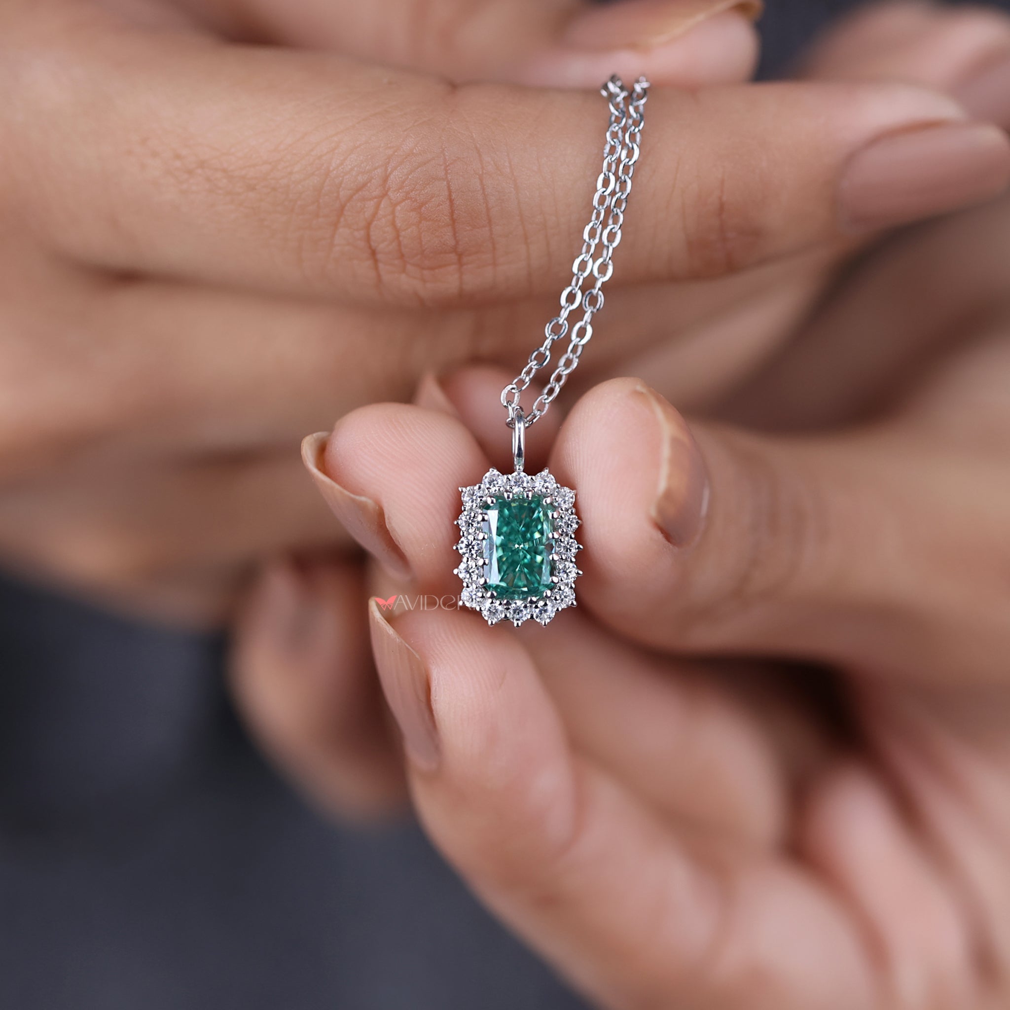 Round cut halo pendant surrounds a radiant stone with sparkling accent diamonds.