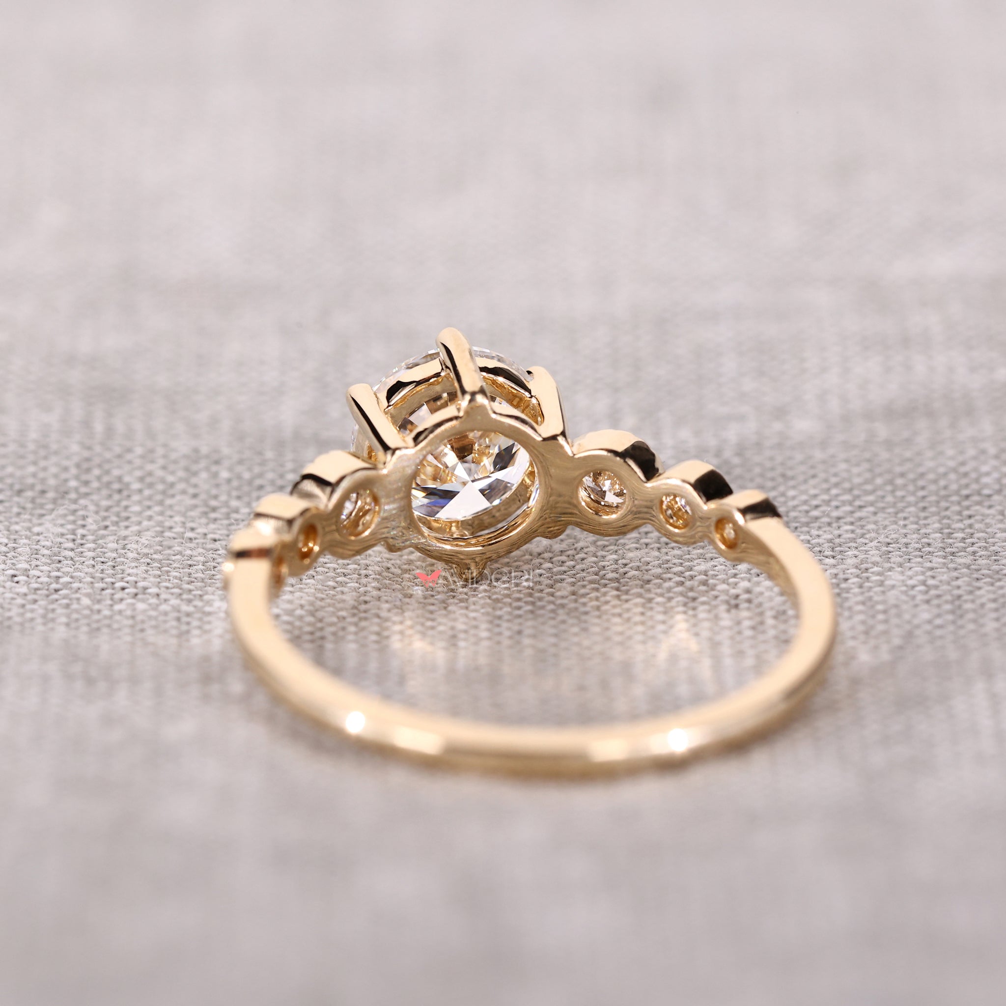 Seven stone diamond ring with round brilliant cut diamond ring accents and a delicate milgrain engagement ring design.
