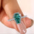 Coffin Cut Cyan Blue ring placed on a soft velvet box.
