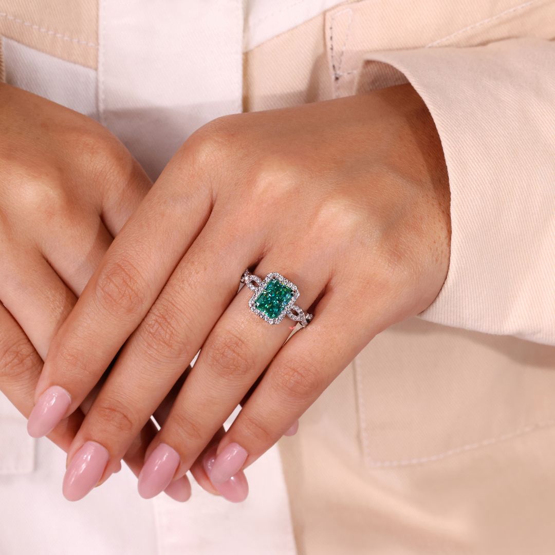 Radiant ring featuring a cyan blue moissanite in a halo setting design.
