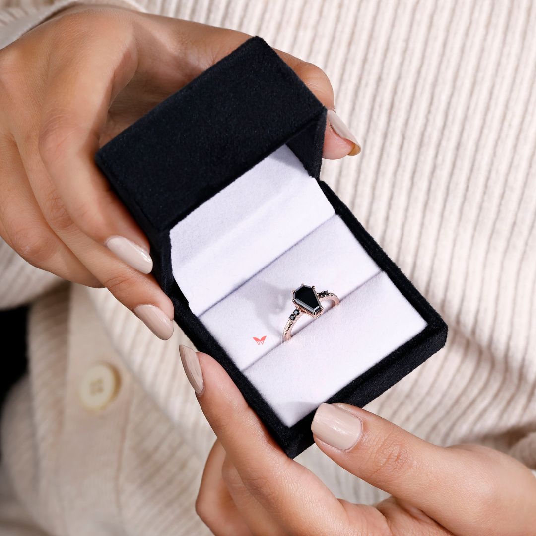 Rose gold ring with a striking coffin engagement ring design.
