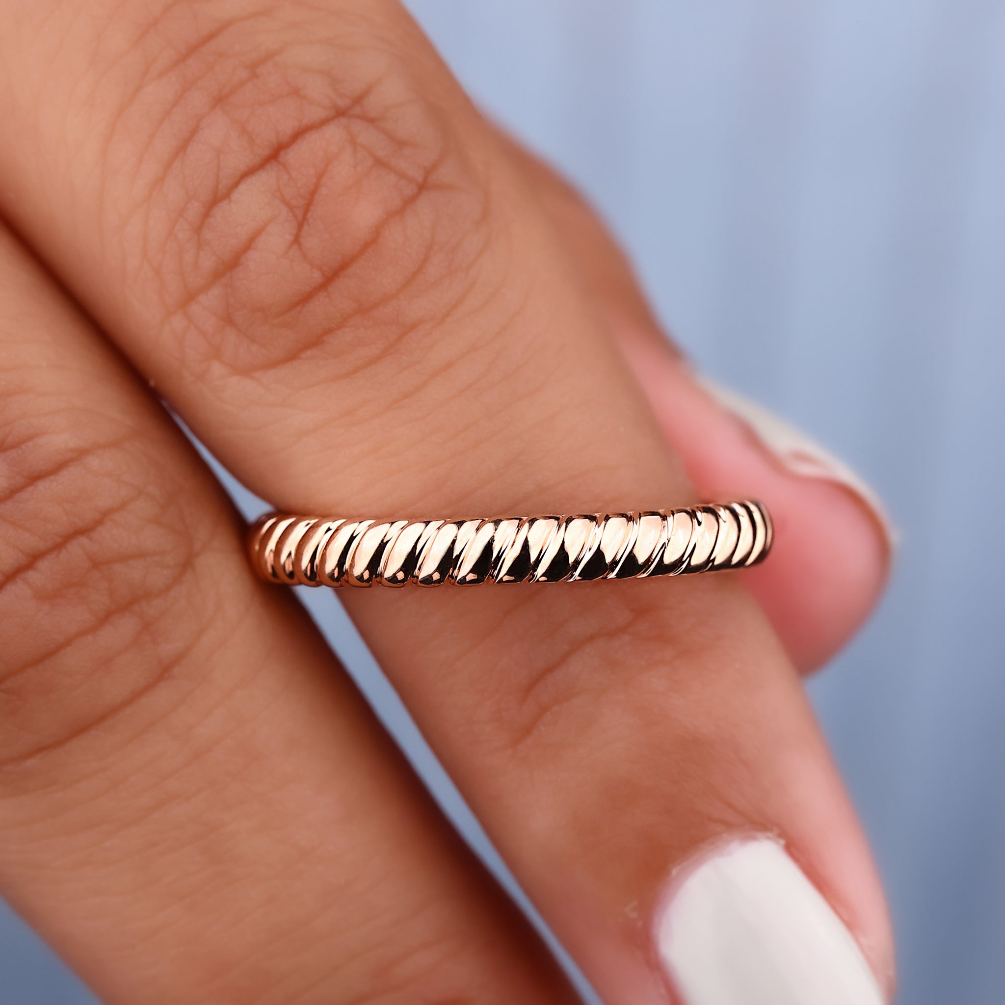 Twisted wedding band adds a modern touch with intricate, intertwined design elements.
