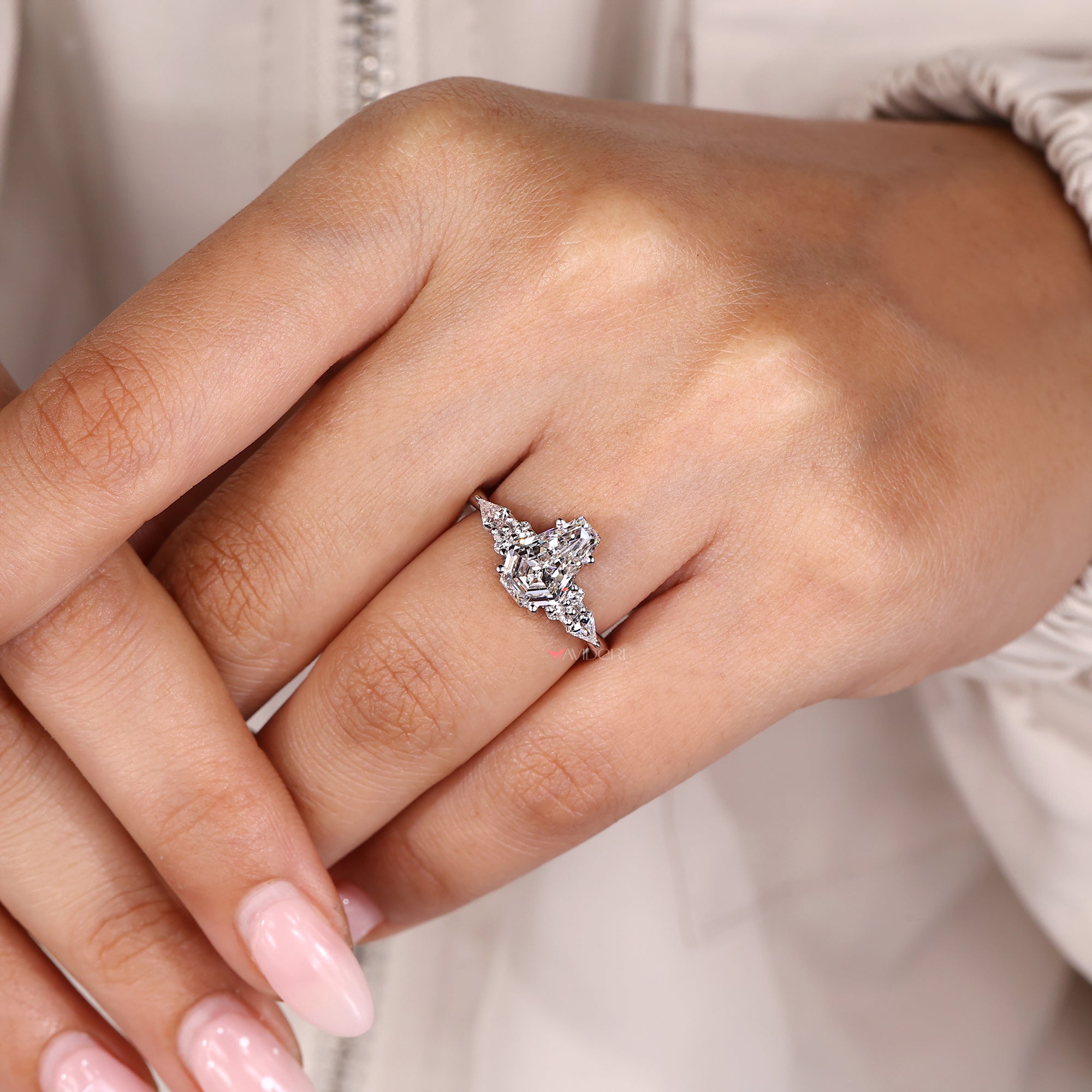 Custom engagement ring with coffin cut and round side stones.