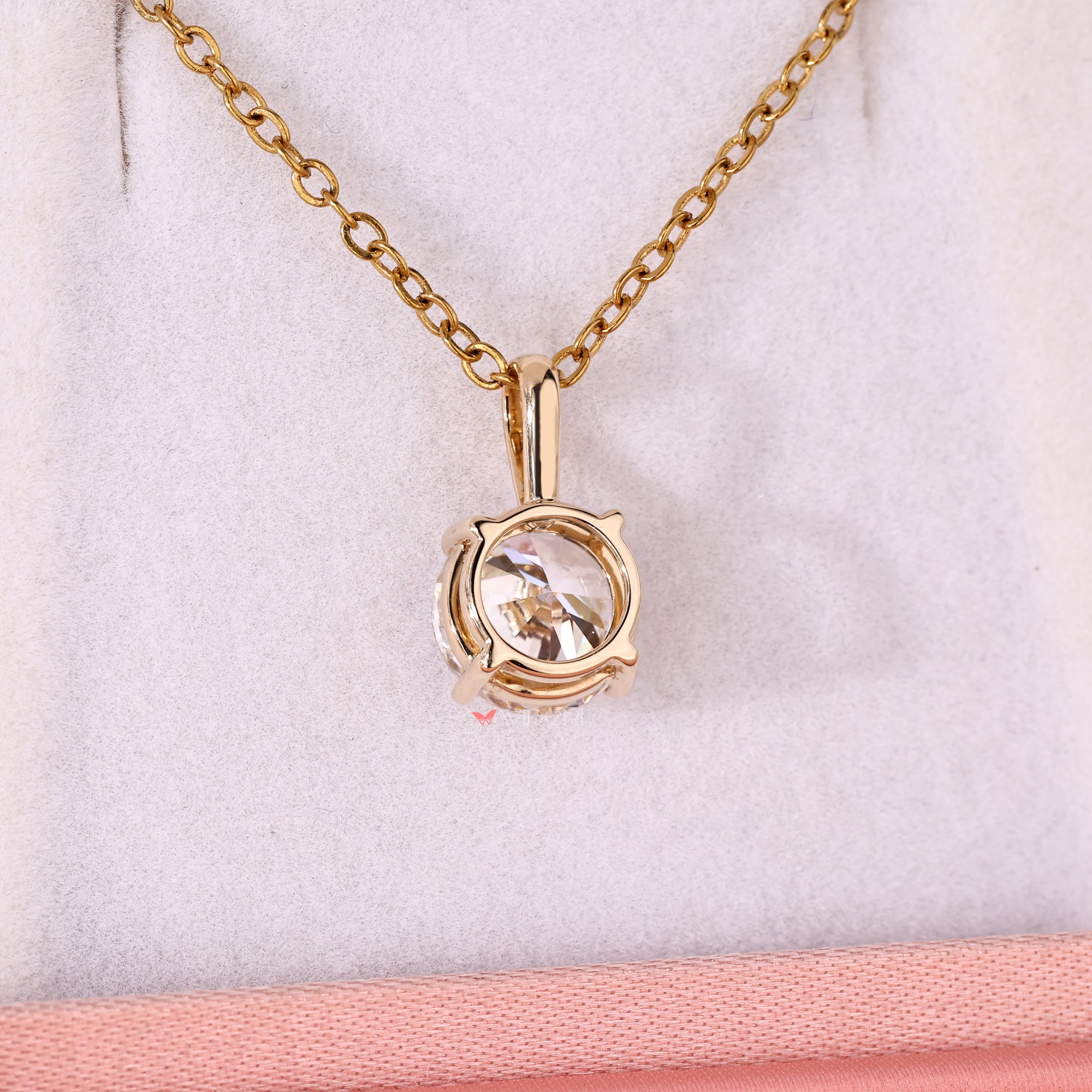 Yellow gold pendant featuring a round solitaire diamond.