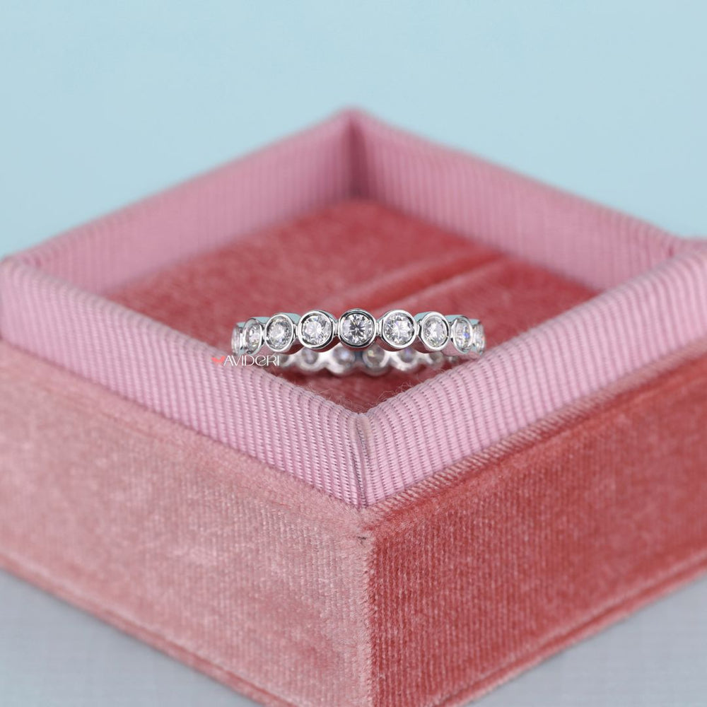 Bezel setting wedding band holds each stone securely with modern elegance.
