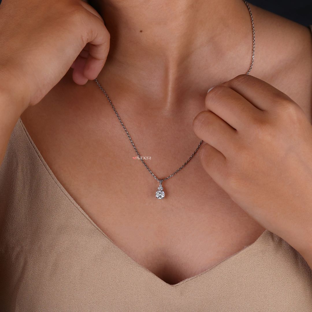 Customize pendant with a round cut moissanite stone in a simple design.
