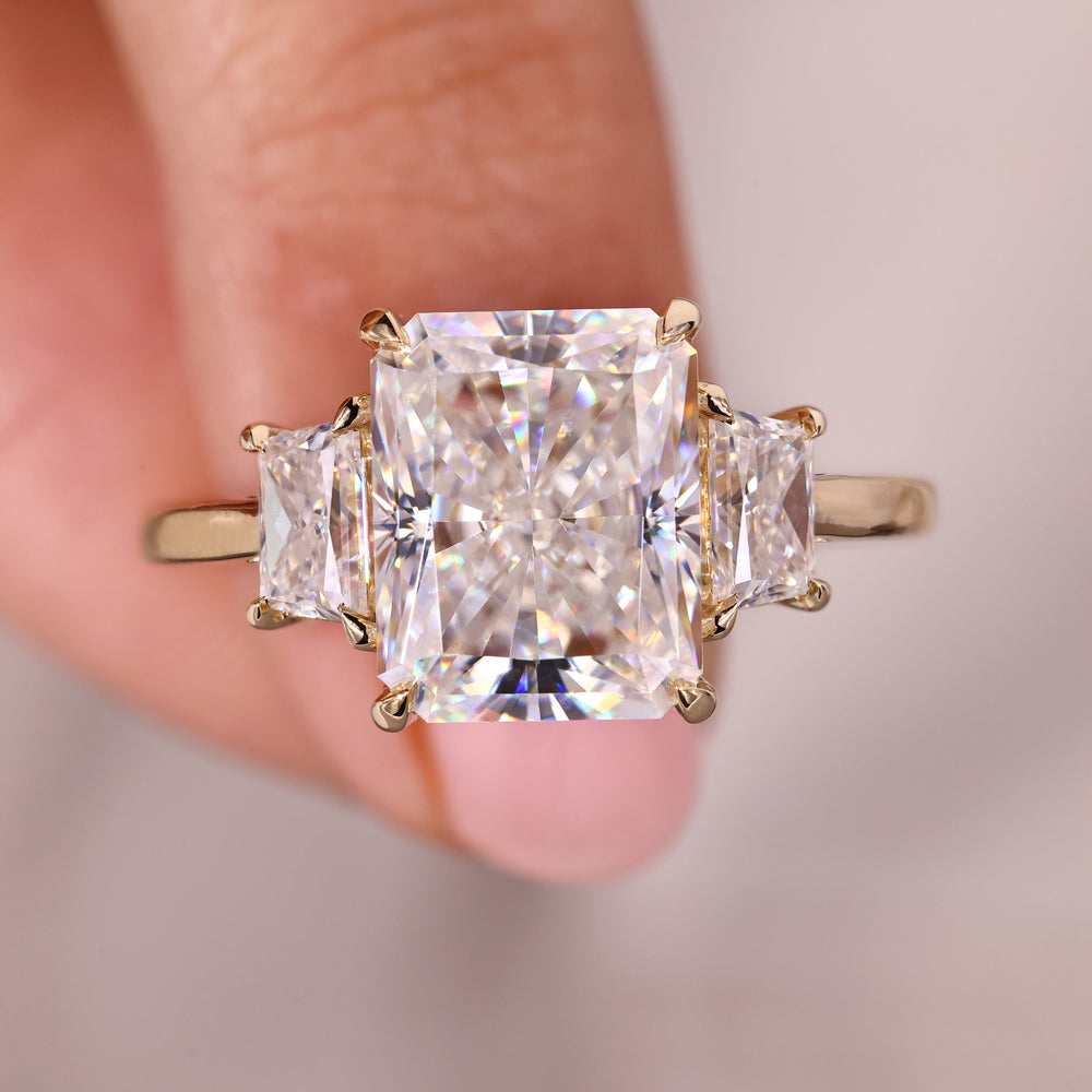 Three stone moissanite ring with radiant cut center.