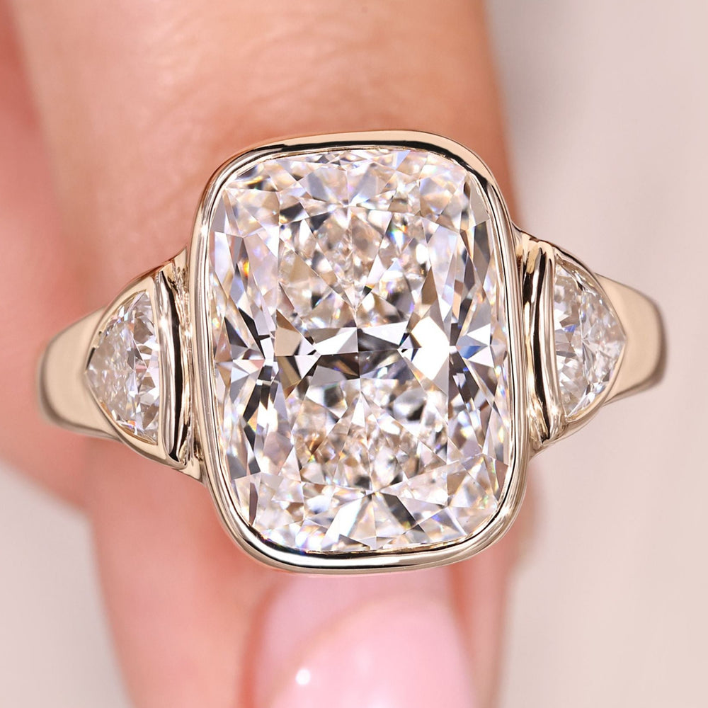 Cushion cut diamond engagement ring in three stone style.