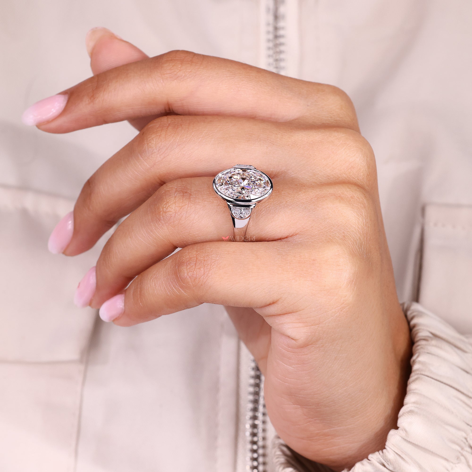 Cathedral setting three stone engagement ring with oval diamond.