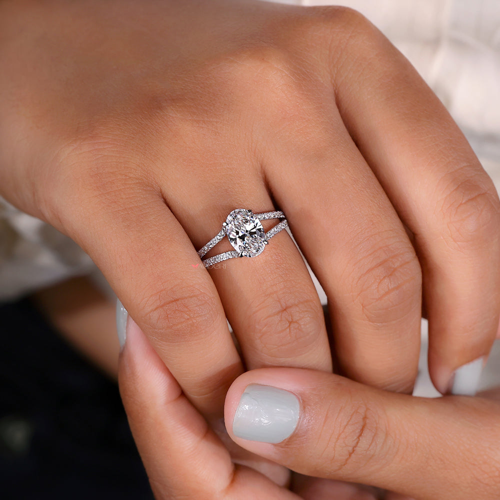 Oval diamond ring with split shank and hidden halo.
