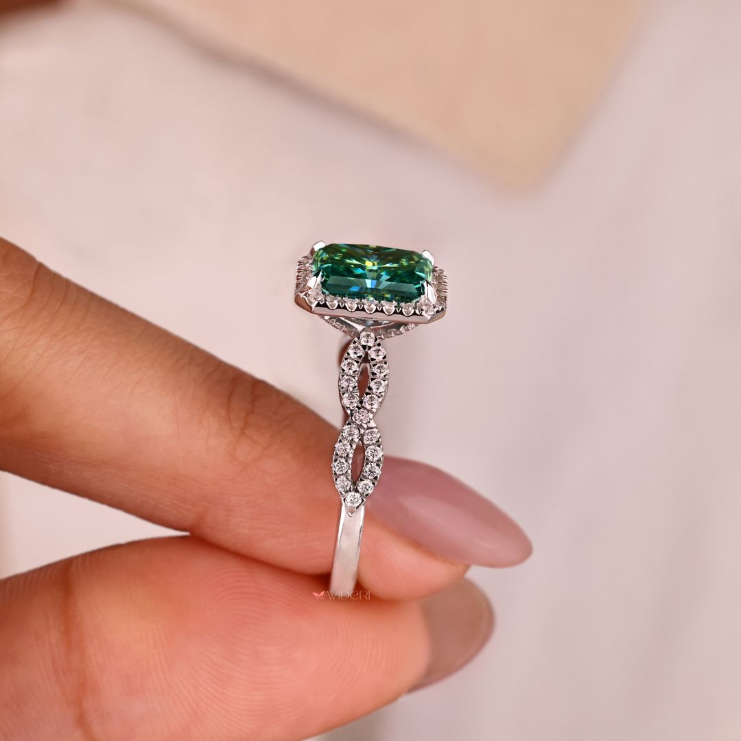 Twisted engagement ring with a cyan blue moissanite center stone.
