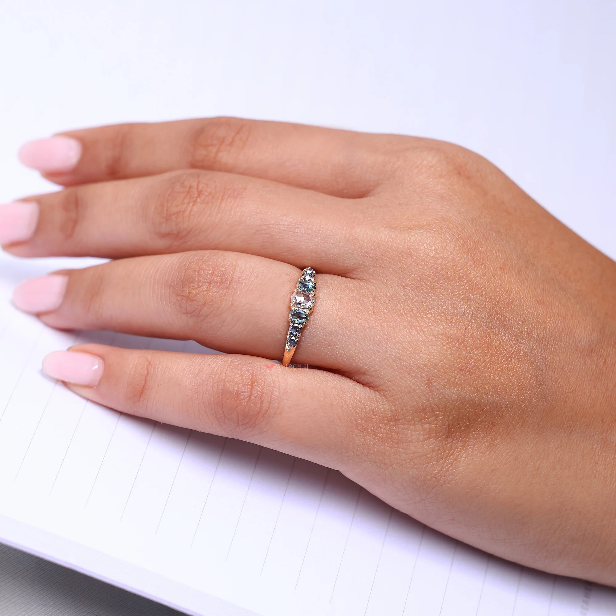 Oval rose cut cyan blue side stone with round cut blue side stone.