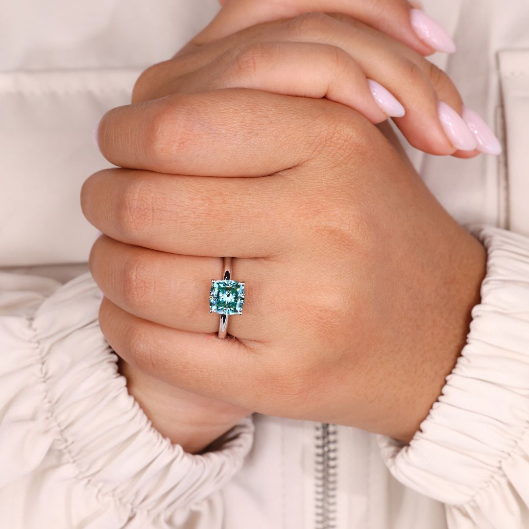 Gold solitaire engagement ring featuring a stunning cushion cut diamond.
