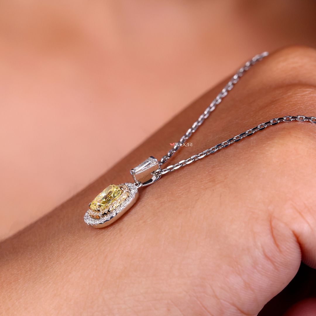 Yellow stone pendant set in a two-tone gold frame.