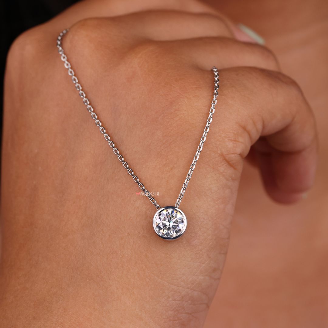White gold pendant featuring a round moissanite stone.
