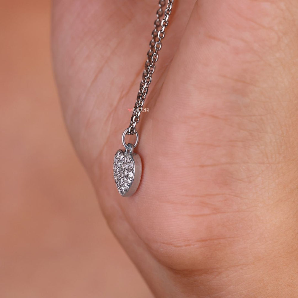 Cluster pendant with a heart shape featuring a round moissanite cut stone.
