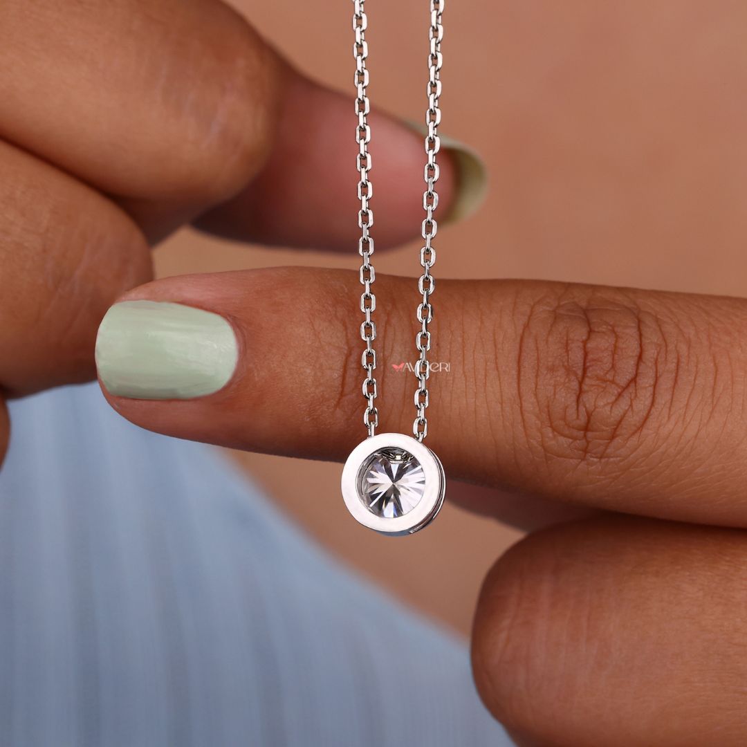 Bezel setting pendant with a round moissanite center stone.
