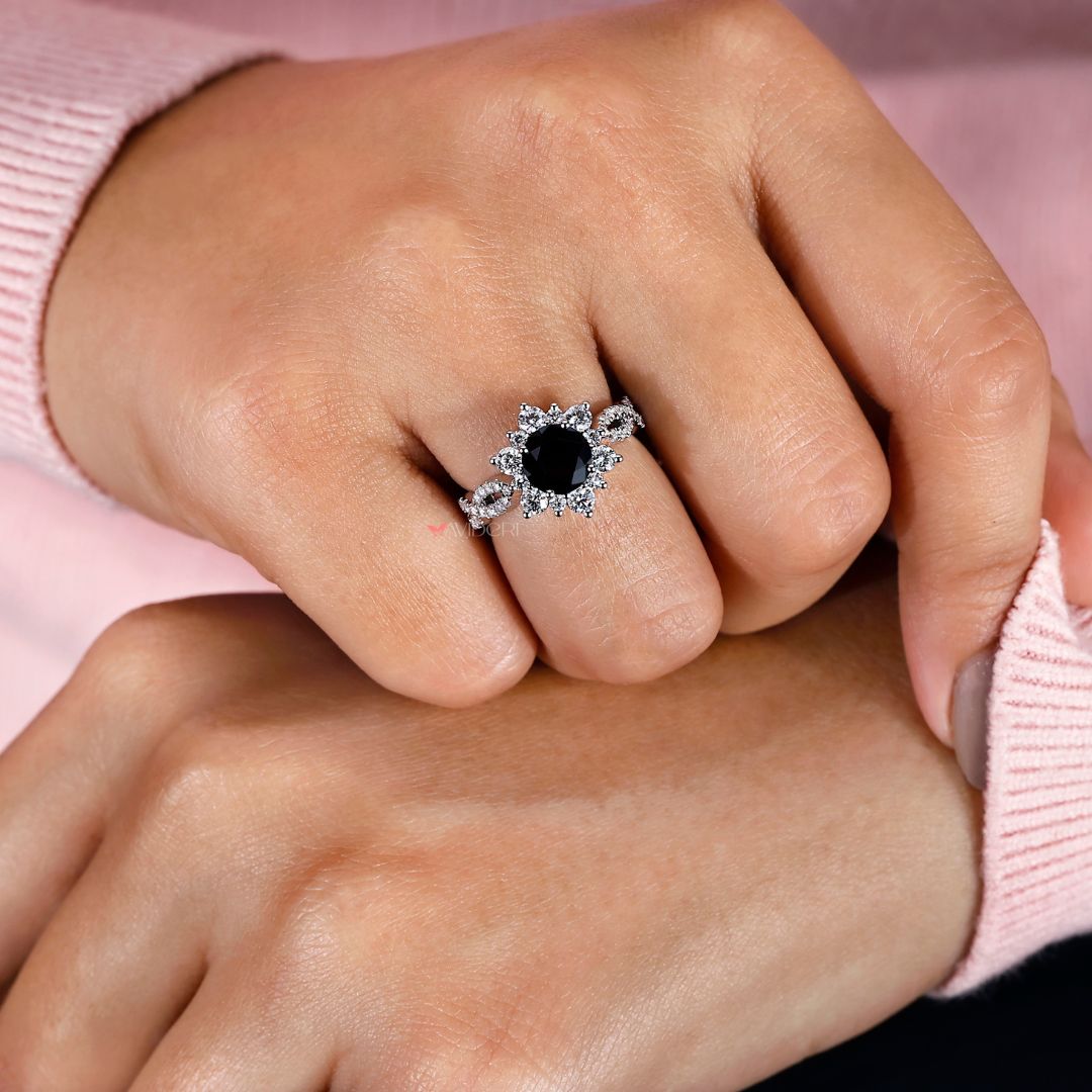 Infinity shank engagement ring featuring a round cut center stone.
