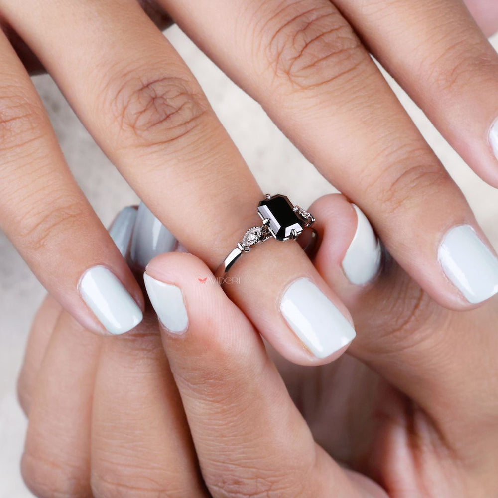 White gold jewelry ring with a cathedral setting and an emerald cut diamond.

