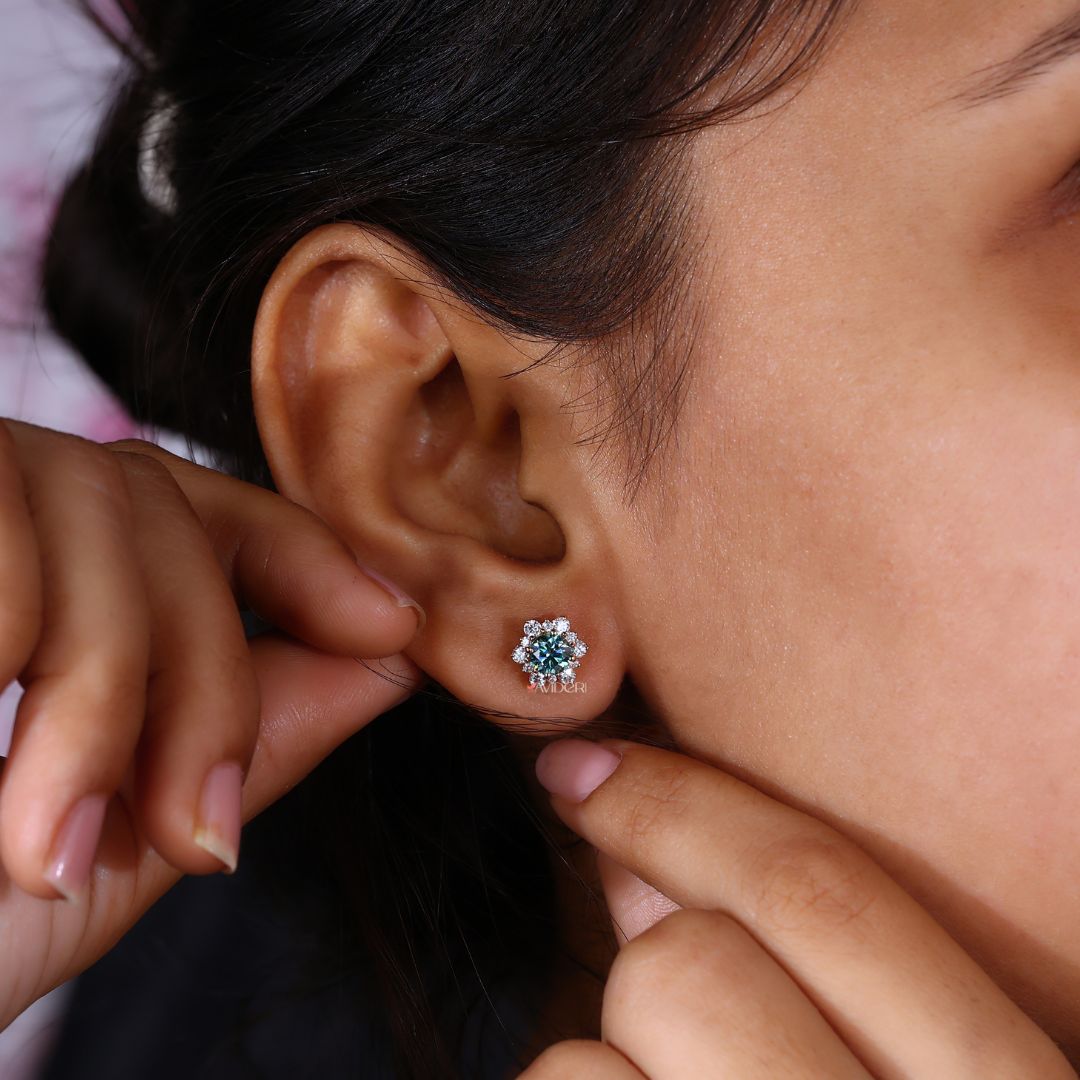 Cyan blue earrings with a halo cluster setting in yellow gold.