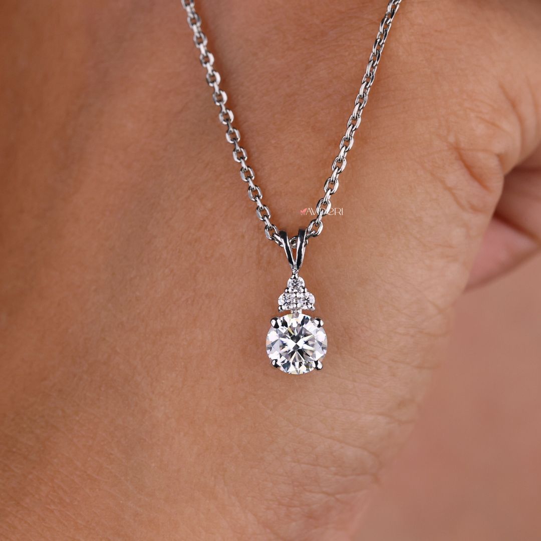 White gold pendant featuring a round cut moissanite stone.
