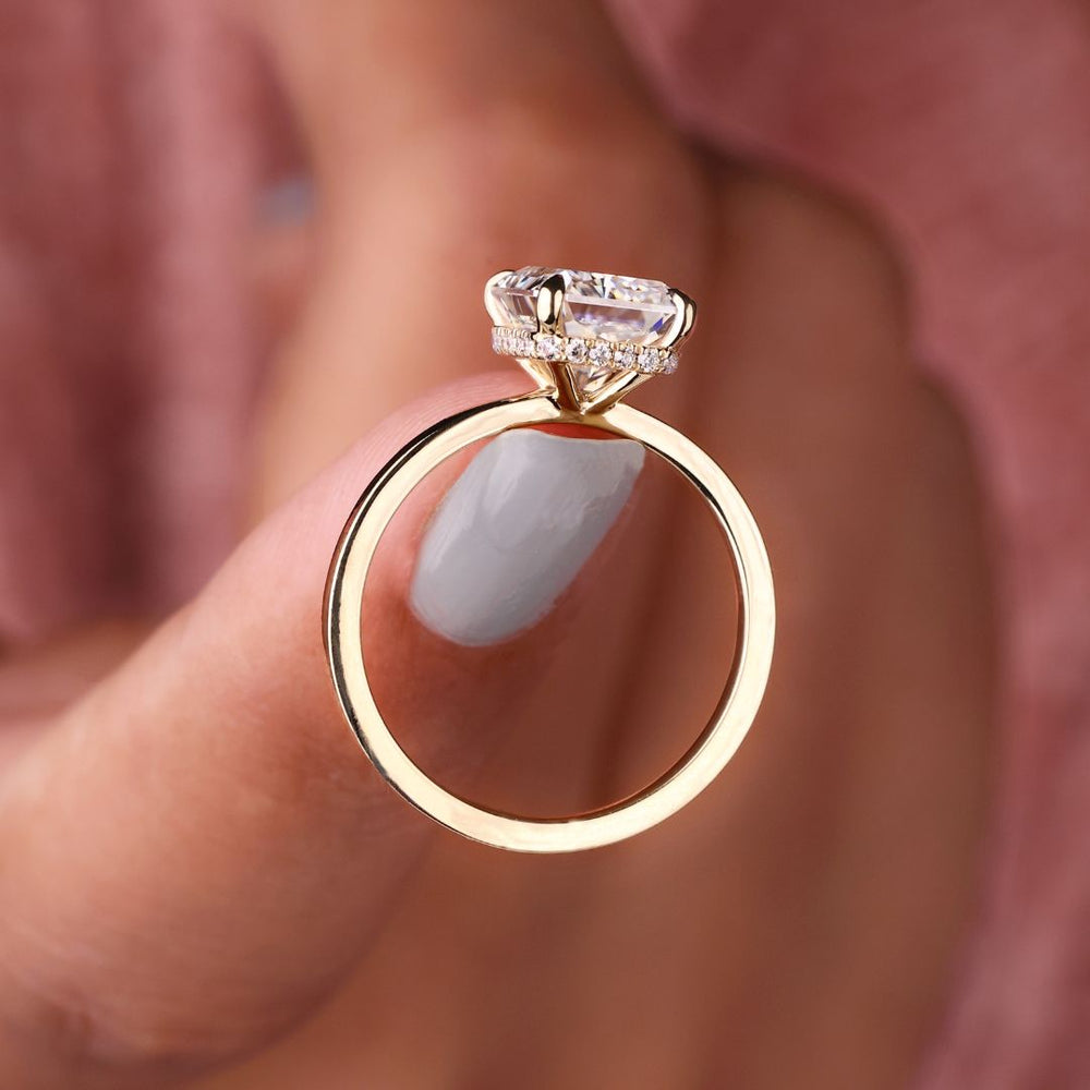 Round cut hidden halo engagement ring with sparkling accents.
