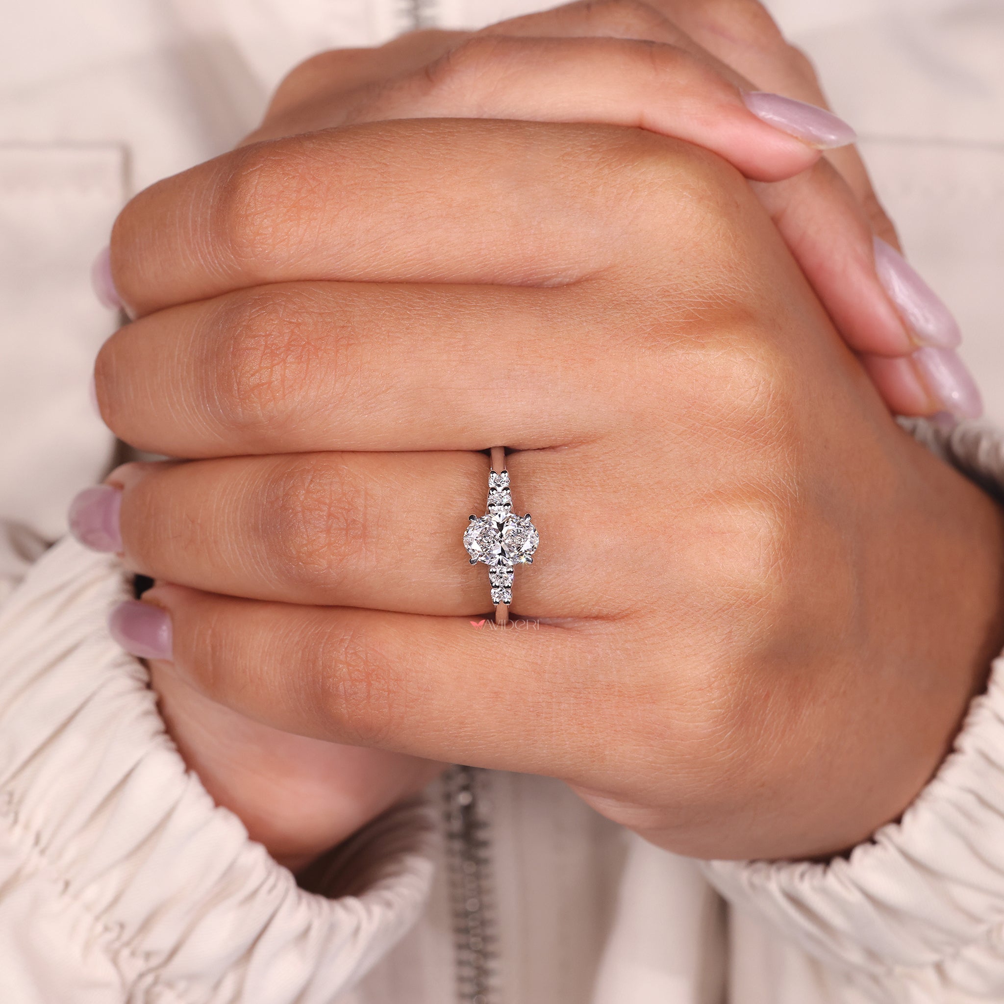 Four claw prong setting used to secure the oval diamond in a clean, modern style.
