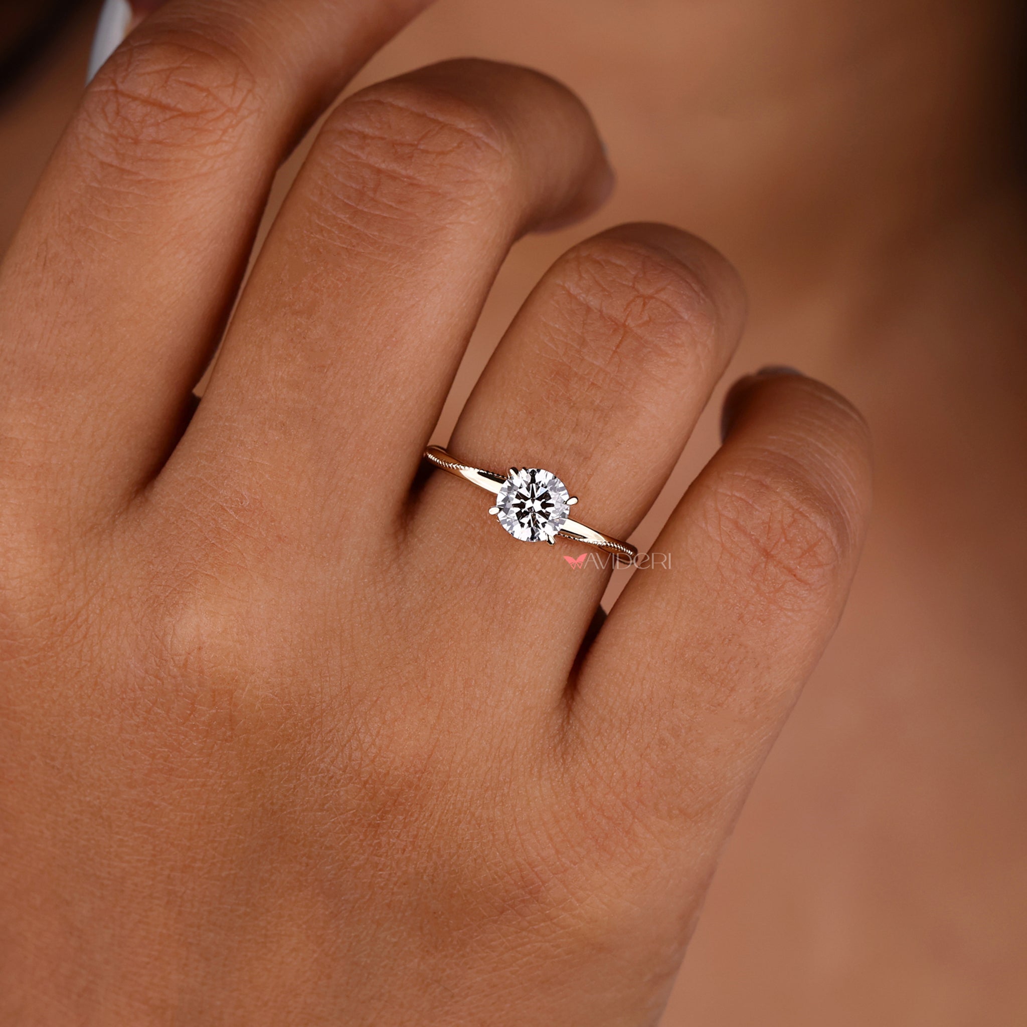 Engagementring featuring a round engagement ring with milgrain accents and a solitaire diamond setting.
