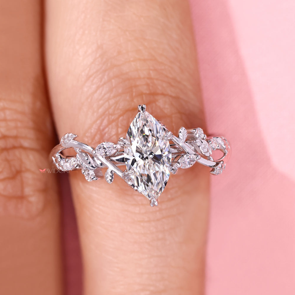 Marquise diamond ring with leaf prong and round stones.
