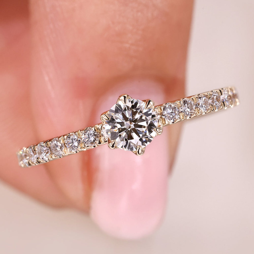 Round cut diamond ring in a round diamond pave setting ring.
