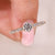 Round cut diamond ring in a round diamond pave setting ring.