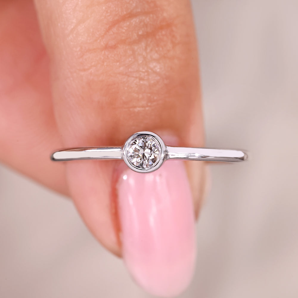Round diamond solitaire ring with modern bezel setting.
