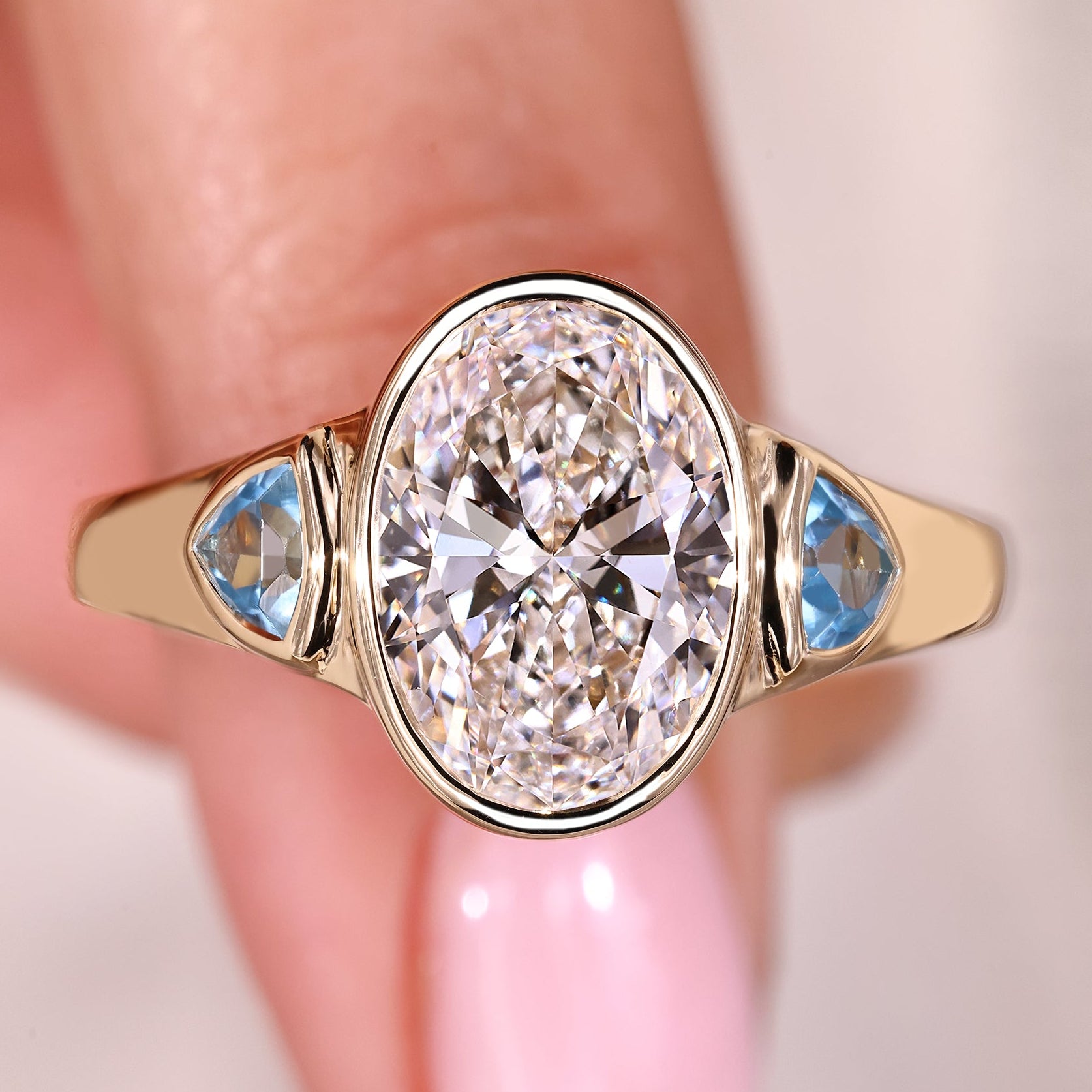Bezel set oval diamond ring in yellow gold setting.